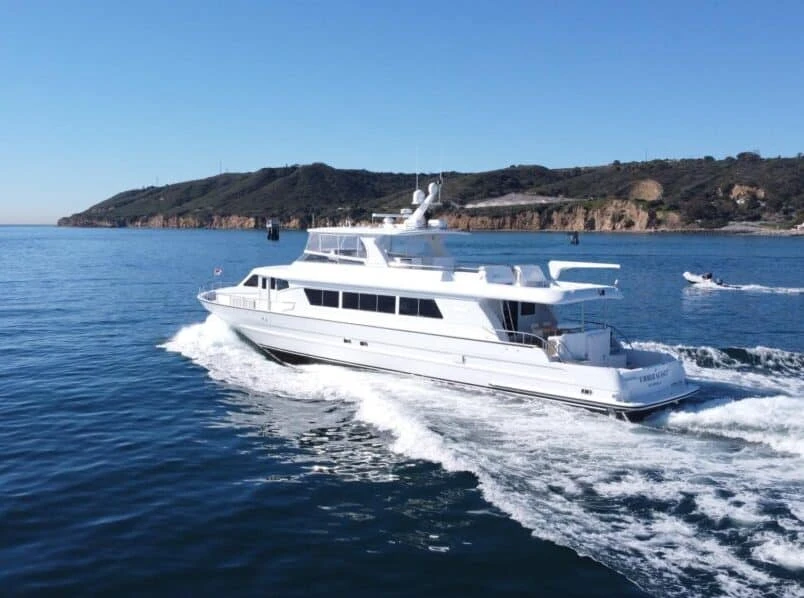 Yacht with scenic water and island views in the background.